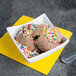 A bowl of Dutch Treat Twinkle Nut Crunch Candy Ice Cream Topping on a bowl of ice cream with a spoon.