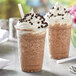 Two cups of Capora Java Chip Frappe with whipped cream and chocolate chips.